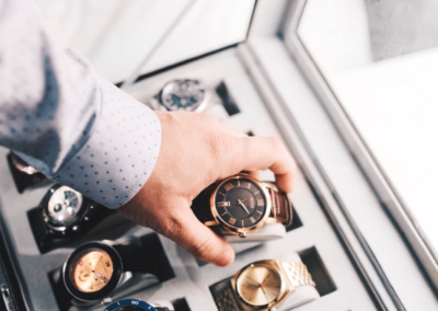 main homme saisit montre de luxe dans un coffret.png